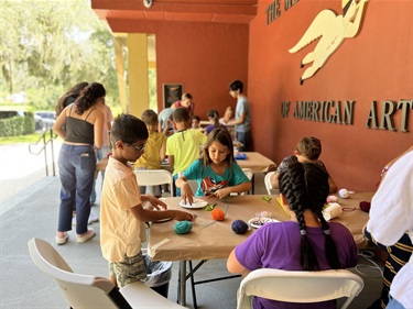 Children enjoying Family Fun Day activities on the front steps of the Mennello Museum of American Art.